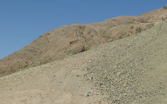 Looking up at the old mine area from the trail up. Two small white specks are rockhounders.